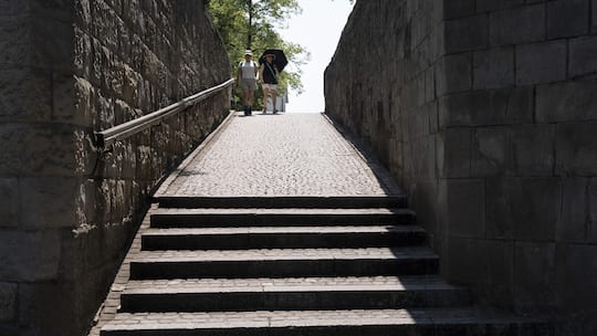 Zwei Personen, die die Treppe des Lindenhofs hinunterlaufen, fotografiert waehrend der Hitzewelle und der extremen Temperaturen um etwa 14:50 Uhr am Donnerstag, 30. Juli 2026, in Zuerich. KEYSTONE/Gaetan Bally)