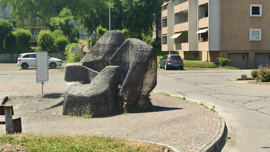 Bildschirmfoto Google Street View vom Steinbrunnen vor der Migros in Dietlikon. Die Brunnenanlage ist eine Arbeit des Künstlers Jürg Altherr. Die Gemeinde hat den Brunnen 2025 ohne Wissen um die Geschichte des Kunstwerks entfernen lassen.