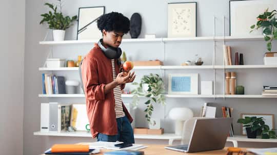 Junger Mann in aufgeräumtem Zimmer - Aufräum-Vorsätze scheitern oft im Februar. Mit festen Admin-Tagen, Visualisierung und der «Eins rein, eins raus»-Regel bleibt die Wohnung dauerhaft sauber