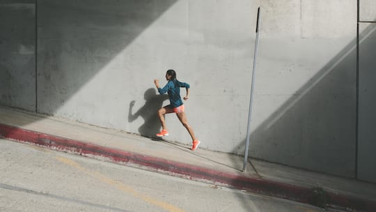 Frau joggt einen Hang hinauf - Wenn jede Joggingrunde zur Qual wird, bleibt die Freude auf der Strecke. Lauflegende Markus Ryffel und Sportmediziner Johannes Scherr wissen, wie man Spass am Laufen bekommt