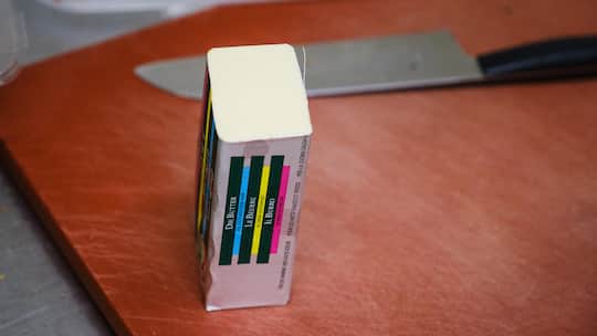 Ein Block Butter auf einem Schneidebreitt - Seit Februar erhalten Bauern weniger für ihre Milch. Doch die Detailhändler geben die Preissenkung nicht immer weiter. Das zeigt der Beobachter-Preis-Check