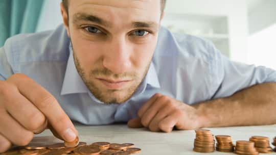 Mann sortiert Kleingeld.