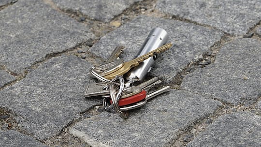 Ein Hausschlüssel liegt auf dem Boden. Geht ein Schlüssel für eine Mietwohnung verloren, stellt sich schnell die Frage, ob die Mieterin dafür aufkommen muss.