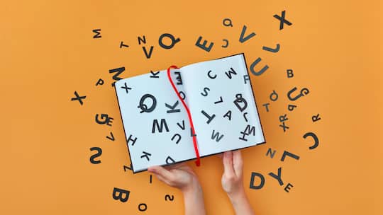 Verschiedene Buchstaben springen aus einem weissen Buch - das Bild symbolisiert eine Lese- und Rechtschreibschwäche.