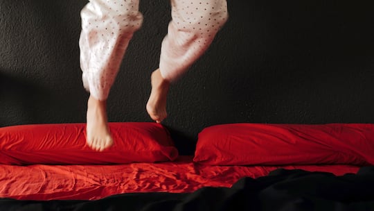 Unruhige Person hüpft auf Bett herum
