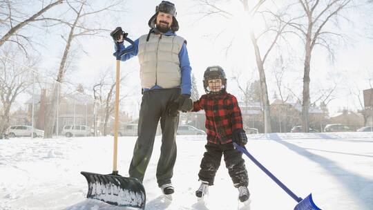 Vater und Sohn beim Schneeschaufeln
