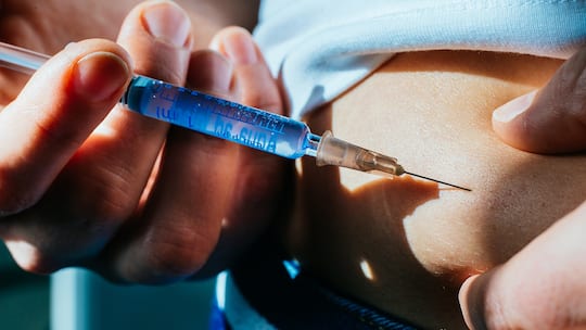 Frau spritzt sich Insulin in den Bauh