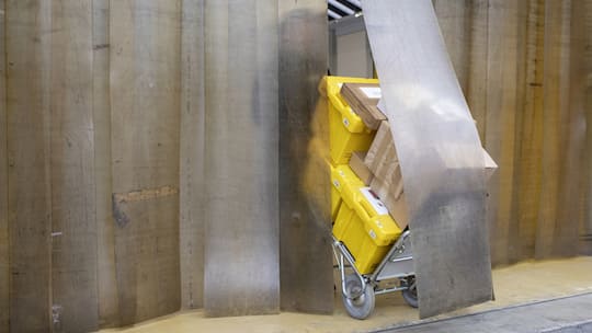 Paketzusteller der Schweizerischen Post Halid Dursun befoerdert Pakete auf einer Sackkarre fuer die Zustellung zum Kunden, aufgenommen am Montag, 15. November 2021 in Zuerich. (KEYSTONE / Ennio Leanza)