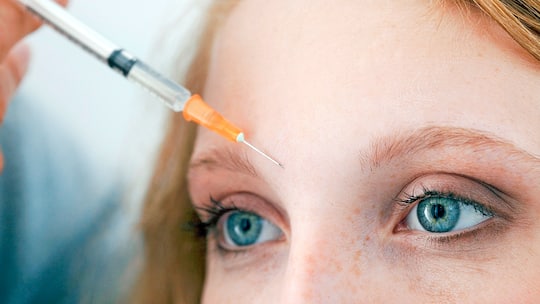 Spritze an der Stirn einer Frau