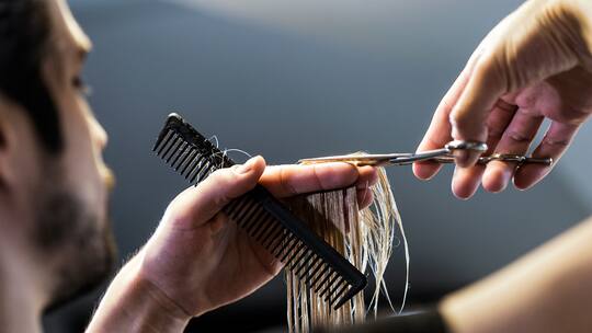 Coiffeur schneidet Haare