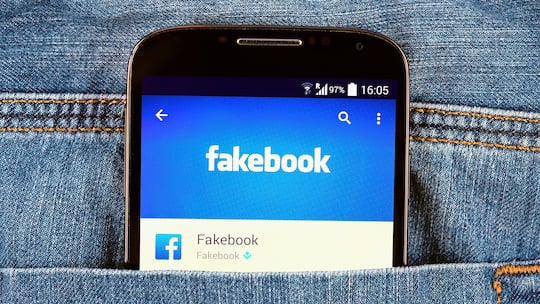 Smartphone in Hosentasche mit Fakebook-Schriftzug