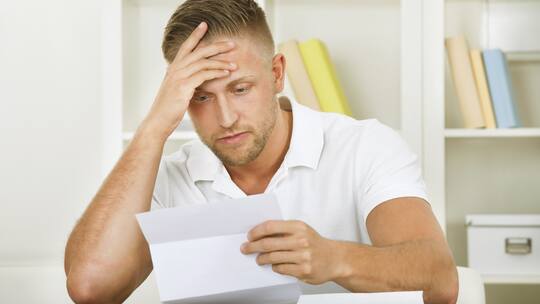 Ein Mann versucht, sein Arbeitszeugnis zu verstehen