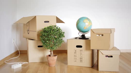 Eine grundsätzlich leer geräumter Raum, in dem einige Kartonschachteln stehen.