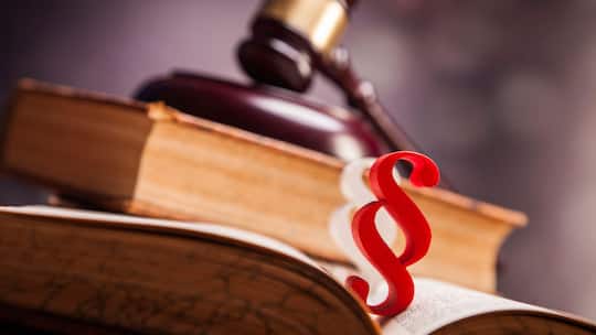 Ein Richterhammer liegt auf Gesetzesbüchern, davor steht ein Paragrafen-Zeichen. Das Schweizer Rechtssystem mag für Laien unübersichtlich sein. Eine Anleitung in 5 Schritten, wie Sie sich zurechtfinden und welche Stellen weiterhelfen können.