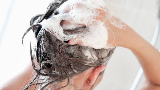 Frau wäscht ihre Haare