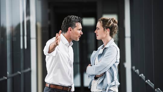 Eine Frau und ein Mann streiten am Arbeitsplatz