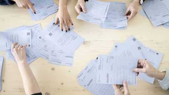 Stimmzettel auf Tisch bei Auszählung