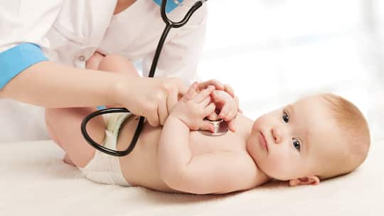 Baby wird von Ärztin mit Stethoskop untersucht.