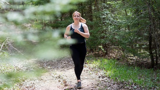 Frau joggt im Wald - Wer mit dem Laufen anfangen will, braucht nicht viel: Ein Paar Laufschuhe und etwas Motivation reichen. 5 Tipps für einen erfolgreichen Start