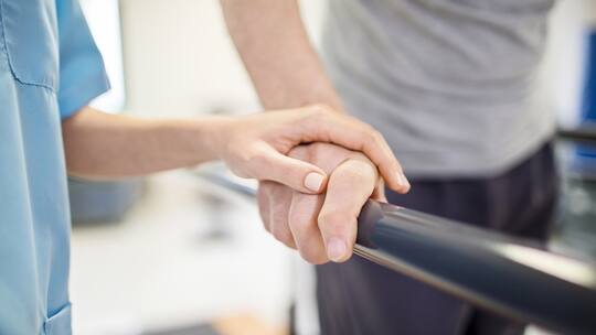 Krankenschwester hält Hand von Mann auf Laufband