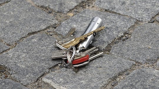 Ein Hausschlüssel liegt auf dem Boden. Geht ein Schlüssel für eine Mietwohnung verloren, stellt sich schnell die Frage, ob die Mieterin dafür aufkommen muss.