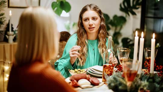 Junge Frau am Familienessen mit der Mutter - Die Entscheidung, kinderfrei zu leben, kann Eltern enttäuschen. Hier sind Ratschläge, um sie behutsam über diesen Lebensweg zu informieren