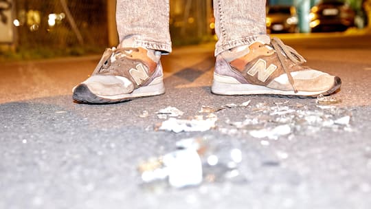 Bruchstücke von Scherben liegen auf einer betonierten Strasse, im Hintergrund steht ein Jugendlicher mit Turnschuhen - Wenn Kinder oder Jugendliche einen Schaden verursachen, stellt sich schnell die Frage, ob sie alleine dafür haften, ihre Eltern oder gar die geschädigte Person. Der Beobachter zeigt auf, wie die Haftungsfrage in der Schweiz geklärt ist.