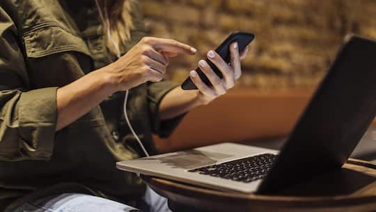 Close up shot of the hands of an unrecognisable woman while working on her cellular phone