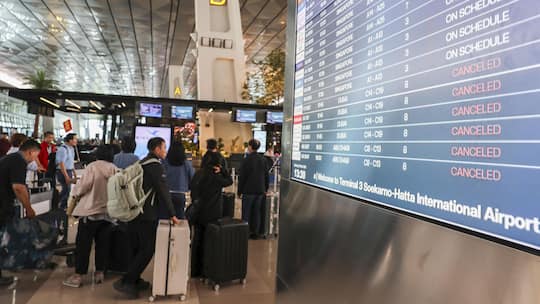 A departure board displays flight cancellations at Soekarno-Hatta International Airport after several flights to Dubai and Doha are canceled following strikes on Iran launched by the United States and Israel and Tehran's retaliatory action, in Tanger…