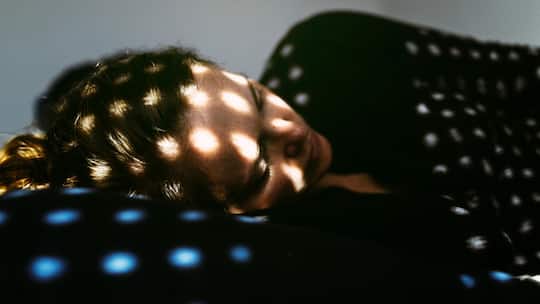 Depressed woman lying on the bed at home.