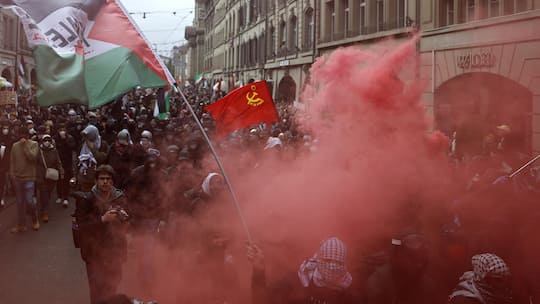 People hold banners and wave Palestinian flags during an unauthorized rally in solidarity with the Palestinian people in Bern, Switzerland, 11 October 2025. (KEYSTONE/Peter Klaunzer)