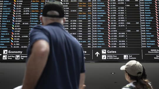 Passagiere schauen auf die Anzeigetafel mit den Abfluegen, am Samstag, 11. Juli 2026, am Flughafen Zuerich in Kloten. (KEYSTONE/Andreas Becker)