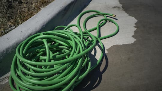 A green water hose lying on the ground. Photographer: Nitashia Johnson/Bloomberg
2149086601