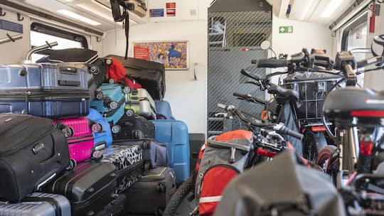 Koffer stapeln sich neben Velos im Gepäckabteil in einem Intercityzug.