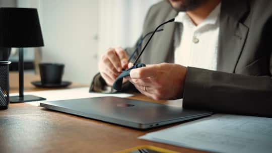 Anonymous businessman cleaning his glasses before starting work in his office. Professional routine, focus and workplace productivity concept.
2793692887