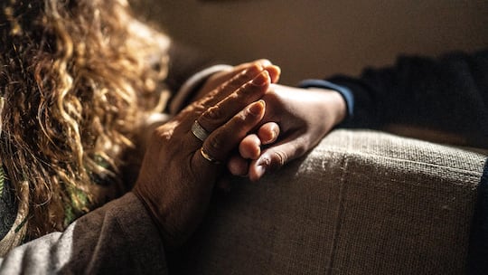 Close-up of mother holding son's hand giving support at home