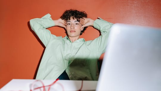 Frau hält Hände am Kopf, Büro, Laptop.