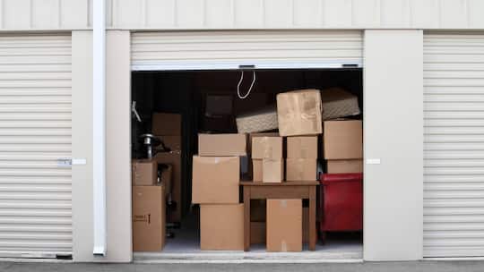 Warehouse building with self storage units. Self storage facility. Roll up doors on self storage facility. One door open with boxes and furniture in doorway.
Original File Name: 157676175