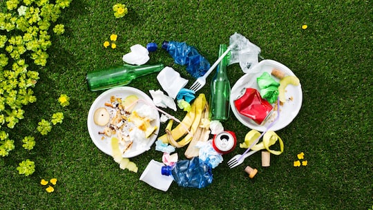 Load of mixed rubbish left on the grass after a picnic, environmental care and waste concept