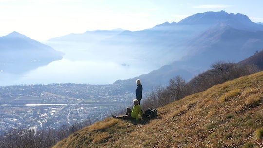 The sun illuminates the distant city, lake and mountains
1292121706