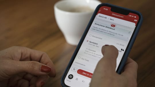 Eine Frau waehlt auf ihrem Smartphone beim Billettkauf auf der SBB-App das Sparbillett fuer die Strecke Zuerich-HB - Bern, fotografiert am Dienstag, 2. Juli 2024 in Zuerich. (KEYSTONE/Christian Beutler)