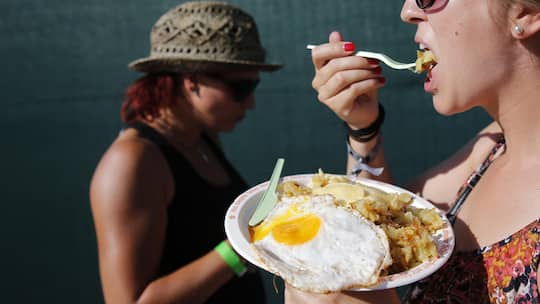 Festival visitors eat 'Roesti' at the Gurten music open air festival in Bern, Switzerland, Thursday, July 16, 2015. (KEYSTONE/Peter Klaunzer)
SCHWEIZ GURTEN FESTIVAL 2015
