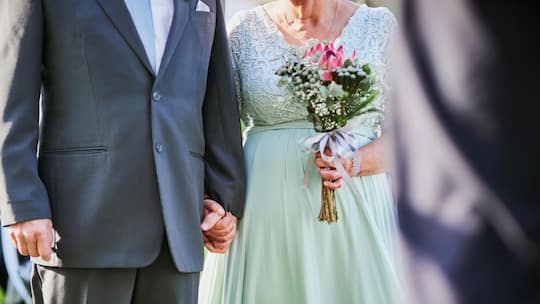 Shot of an unrecognizable senior couple walking hand in hand together outdoors on their wedding day