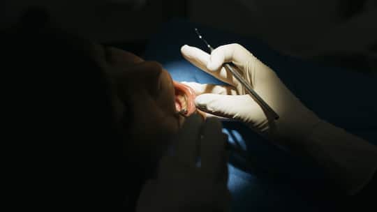 Hygienist dentist During a Dental Intervention to a boy