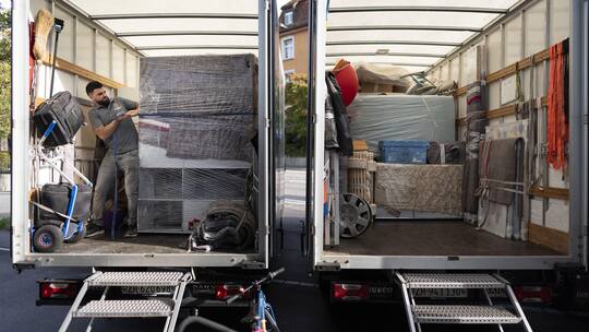Mitarbeiter eines Umzugsunternehmens fuellen bei einem Umzug Lastwagen mit Mobiliar, fotografiert am Montag, 23. September 2024 in Zürich. (KEYSTONE/Gaetan Bally)