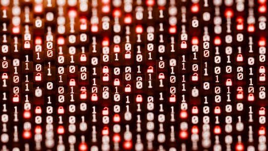 2268988405 A horizontal conceptual image featuring a massive, dense field of glowing white binary code and red padlock icons resting on dark blocks. The scene serves as a visual metaphor for the overwhelming scale of big data, the persistent threat o…