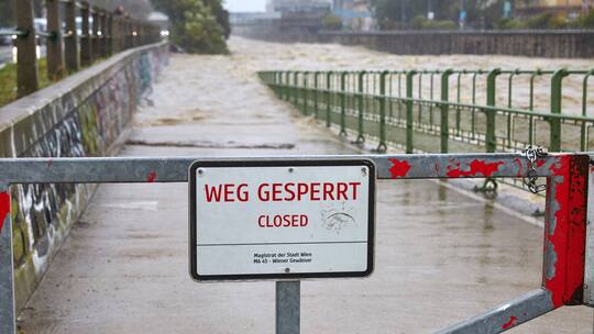Ein Gehweg entlang eines Flusses in der Stadt Wien ist wegen des Hochwassers gesperrt. Welche Rechte haben Reisende, deren Pläne wegen des Unwetters in Osteuropa über den Haufen geworfen werden?