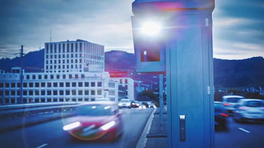 Auto rast mit hoher Geschwindigkeit auf der Strasse und wird geblitzt.