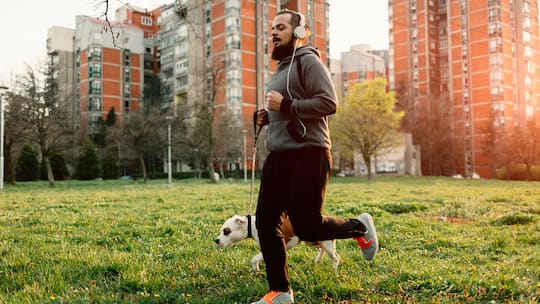 Ein Mann joggt mit seinem Hund.