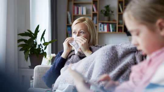 Mutter sitzt krank auf dem Sofa